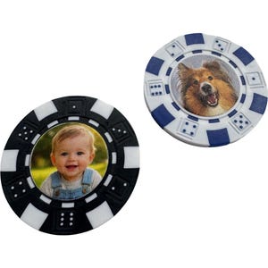 May include: Two personalised poker chips. One black and white chip features a baby's photo, the other blue and white chip has a dog's photo. Both chips have dice markings around the edges.