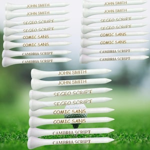 May include: A set of white golf tees with different names and fonts printed on them, including "John Smith", "Segeo Script", "Comic Sans", and "Cambria Script".