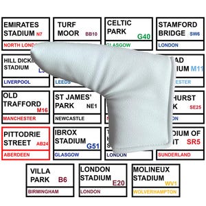 Puede incluir: Una funda blanca para la cabeza del palo de golf, diseñada para proteger la cabeza del palo. La funda se muestra sobre un fondo de letreros de estadios, incluyendo "PITTODRIE STREET" e "IBROX STADIUM".