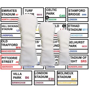 Könnte beinhalten: Weiße Golfschlägerhauben mit Stadionnamen wie Emirates Stadium, Celtic Park und Old Trafford. Der Hintergrund zeigt Schilder mit Stadionnamen und -orten. Die Bezüge bestehen aus einem weichen Material.