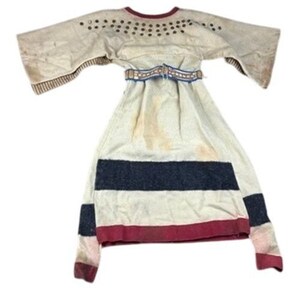 May include: An off-white tunic with wide sleeves, featuring a row of metallic studs along the neckline, a woven belt at the waist, and horizontal stripes in dark gray and deep red at the hem and sleeve cuffs, with a maroon trim at the collar.