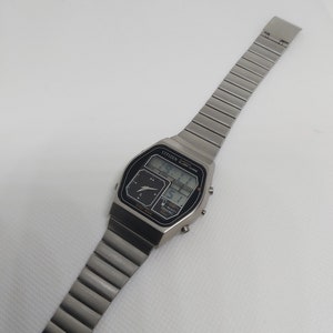 May include: A silver Citizen analog-digital watch with a black face and a silver metal band. The watch face displays the time, date, and day of the week.