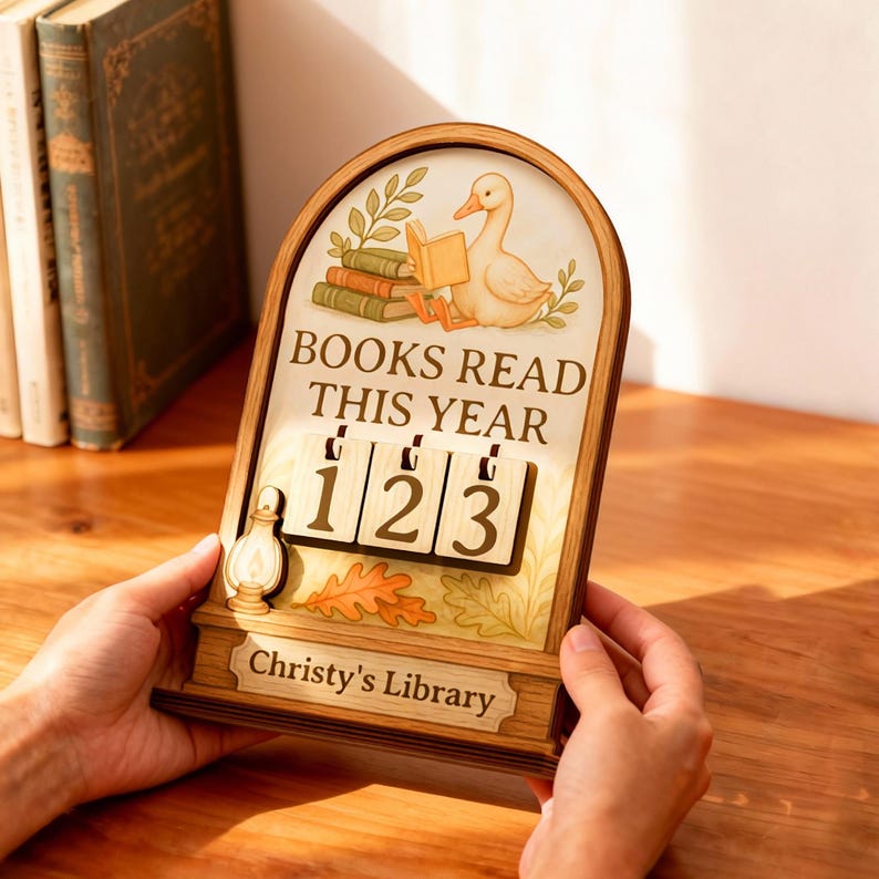 May include: Wooden book counter with a duck reading a book illustration. The text reads "BOOKS READ THIS YEAR" with the numbers "123" displayed. The bottom of the counter reads "Christy's Library".