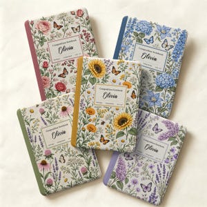 May include: Five composition notebooks with floral and butterfly patterns. Each cover features the name Olivia, the text Composition Notebook, 200 Pages, College Ruled, and 9.75 x 7.5. The notebooks have colored spines in red, blue, yellow, green, and purple.