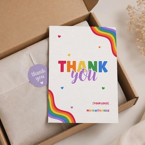 Könnte beinhalten: Eine weiße rechteckige Dankeskarte mit regenbogenfarbenen Wellenstreifen in den Ecken, kleinen bunten Herzen und dem Text THANK YOU in fetten Buchstaben sowie dem zusätzlichen Text [YOUR LOGO] und MADE WITH PRIDE am unteren Rand.