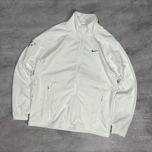 Puede incluir: Chaqueta deportiva blanca con cremallera y cuello alto. Presenta un logotipo de Nike verde en el pecho y un logotipo verde en la manga izquierda. Incluye dos bolsillos laterales y cremallera.