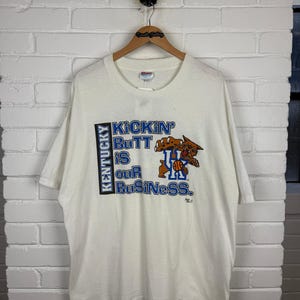 Vintage 90s Kentucky Wildcats Basketball NCAA Kickin Butt Is Our Business T Shirt Size XXL