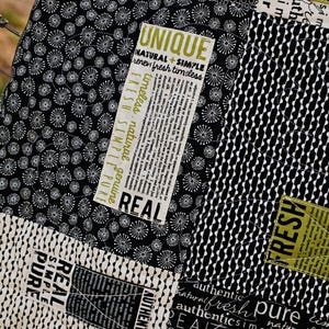 Könnte beinhalten: Ein schwarz-weißes Stoffmuster mit einem sich wiederholenden Muster aus kleinen Kreisen. Der Stoff hat ein Etikett mit den Worten "UNIQUE", "NATURAL + SIMPLE", "renew fresh timeless", "REAL", "FRESH SIMPLE PURE" und "AUTHENTIC" darauf gedruckt.