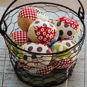 May include: A wire basket filled with colorful fabric balls. The balls are made of patchwork fabric with different patterns, including polka dots, checkered, and floral designs.