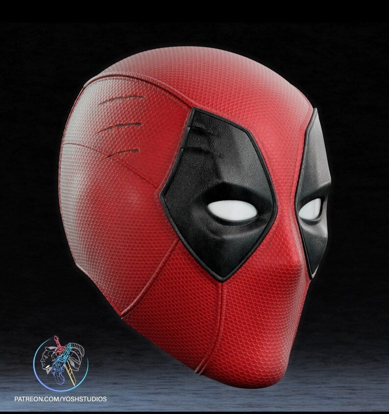 May include: A red and black Deadpool mask with a textured surface. The mask has a black eye mask with white eyes.