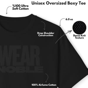 Puede incluir: Camiseta unisex negra de corte holgado y holgado, confeccionada en 100% algod&oacute;n Airlume. La camiseta presenta una construcci&oacute;n de hombros ca&iacute;dos y una textura de punto denso. La camiseta pesa 170 gramos. El texto "WEAR NOBLE" es visible.