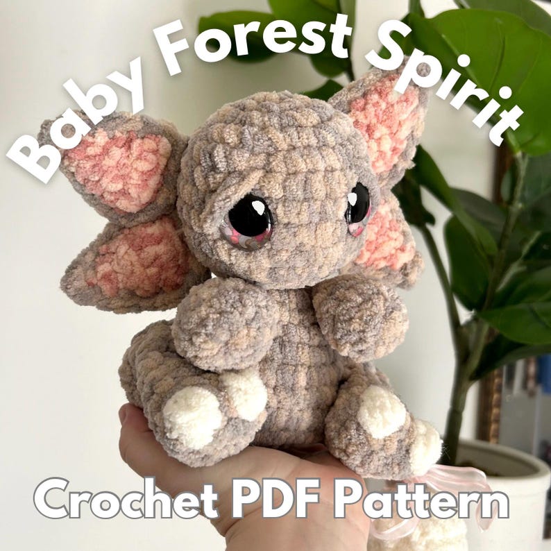 K&ouml;nnte beinhalten: H&auml;kelanleitung f&uuml;r einen Baby-Waldgeist-Amigurumi. Das Pl&uuml;schtier ist grau mit rosa Ohren und wei&szlig;en F&uuml;&szlig;en. Die Anleitung ist als PDF-Download erh&auml;ltlich.