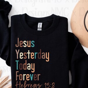 Puede incluir: Sudadera negra con un diseño gráfico colorido que dice "Jesús Ayer Hoy Por Siempre Hebreos 13:8".