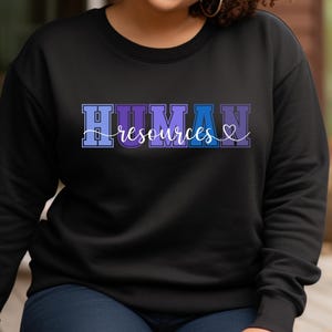 May include: A black sweatshirt with a colorful graphic that says "HUMAN resources" with a heart symbol.