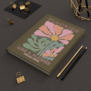 Puede incluir: Un diario marrón con un diseño floral y el texto "Flourish Like a Flower, Psalms 103:15".
