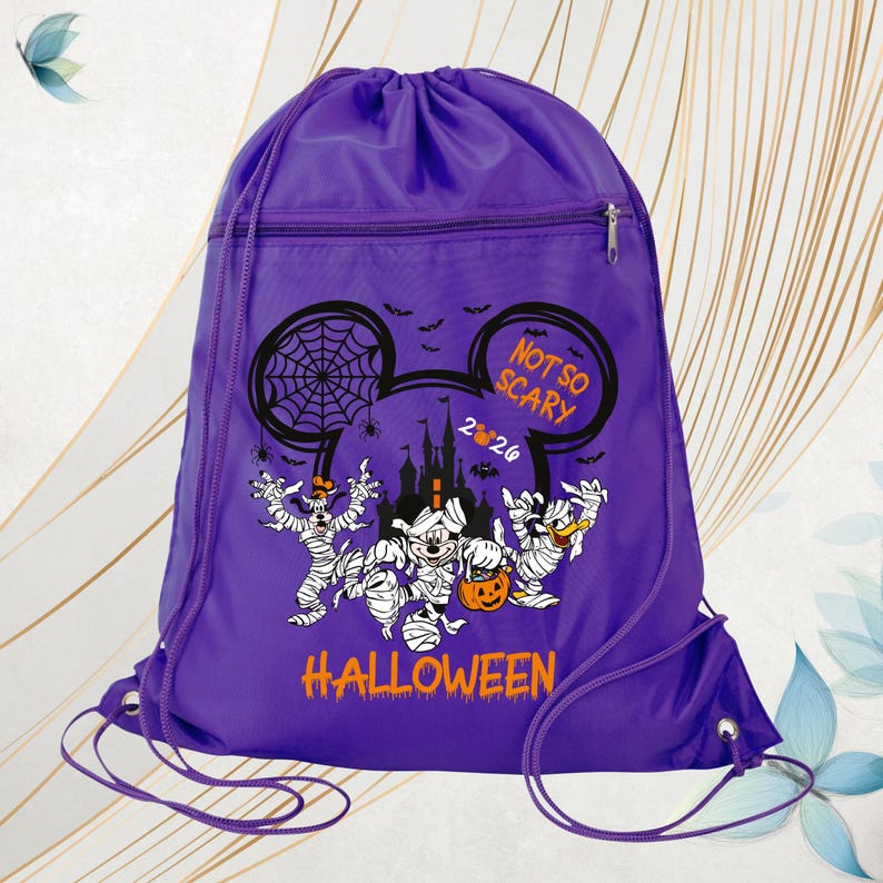 May include: A purple drawstring backpack featuring a graphic of Disney characters dressed as mummies. The design includes a castle silhouette, spiderwebs, bats, and the text "NOT SO SCARY 2024 HALLOWEEN" in orange and white lettering.