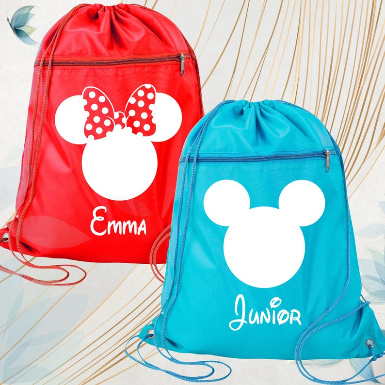 May include: Two drawstring bags, one red and one blue. The red bag features a white Minnie Mouse design with a polka dot bow and the name "Emma". The blue bag has a white Mickey Mouse design and the name "Junior". Both bags have a zipped pocket.