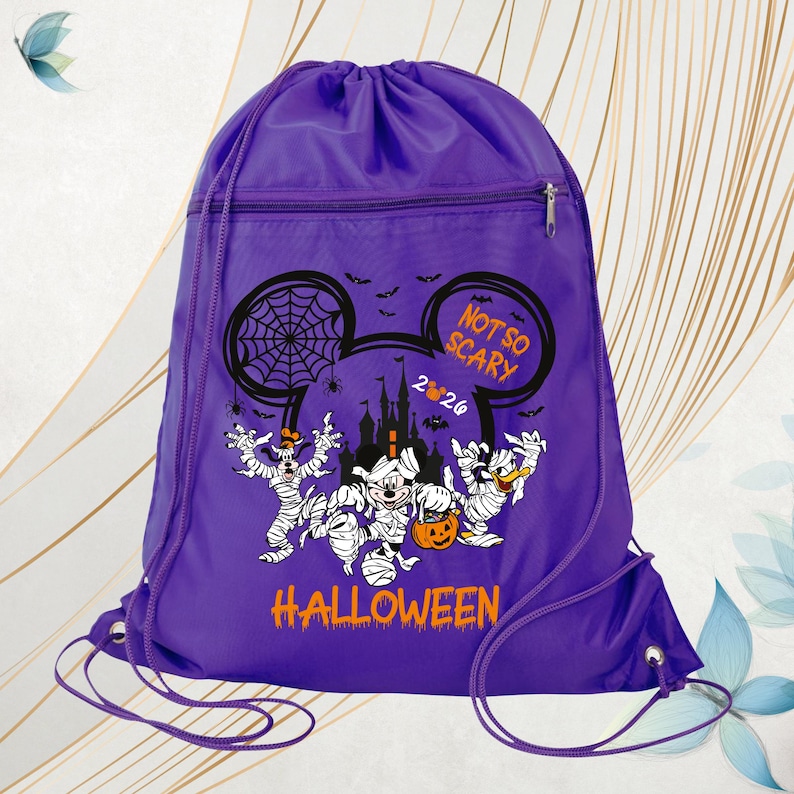 May include: A purple drawstring backpack featuring a graphic of Disney characters dressed as mummies. The design includes a castle silhouette, spiderwebs, bats, and the text "NOT SO SCARY 2024 HALLOWEEN" in orange and white lettering.