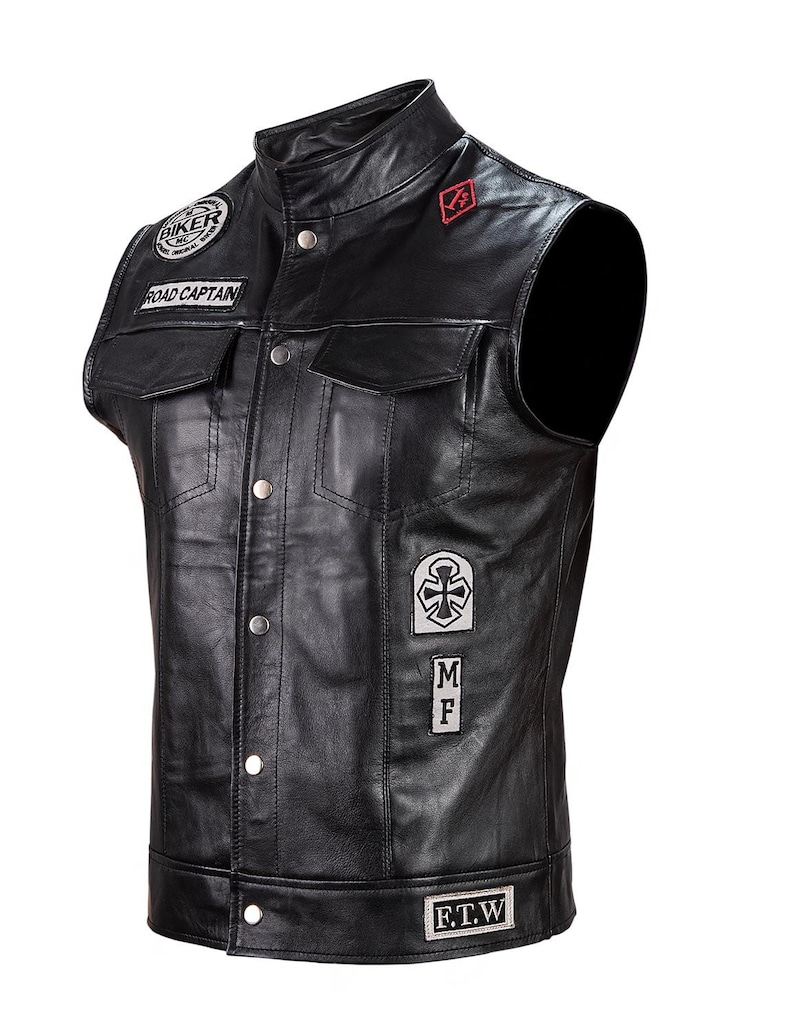 May include: Black leather motorcycle vest with multiple patches, including "Biker", "Road Captain", "F.T.W.", a cross, and "M.F."