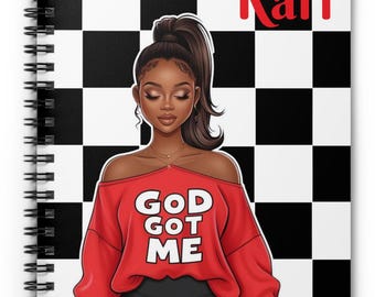 May include: Spiral-bound notebook featuring a stylized illustration of a woman wearing a red off-the-shoulder sweater with the text "GOD GOT ME." The notebook has a black and white checkered background and the name "Kari" in red.