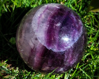 天然の虹色のインクルージョンを含む紫色の蛍石球
