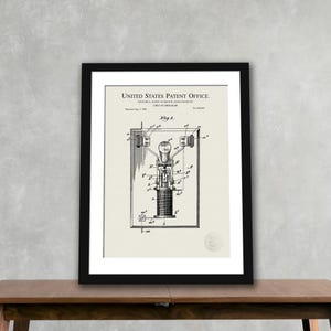 May include: Framed print of a vintage circuit breaker patent diagram. The diagram is in black and white, with detailed technical illustrations and text from the United States Patent Office. The print is in a black frame.