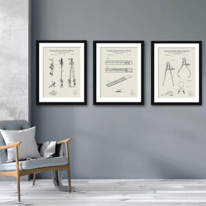 May include: Three black framed prints of vintage United States Patent Office drawings of drafting tools. The drawings show a compass, a ruler, and a protractor.