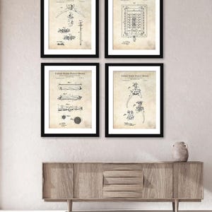 Peut inclure: Quatre impressions de brevets encadrées dans des cadres noirs. Les impressions présentent des dessins techniques, dont un cintre, un terrain de sport et d'autres conceptions mécaniques. Le texte "UNITED STATES PATENT OFFICE" est visible sur chaque impression.