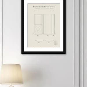 May include: Black and white line drawing of a patent for an electronic device. The patent is titled "United States Patent Office" and the device is a portable music player. The patent drawing shows the device from different angles.
