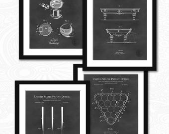 May include: Four black framed prints of vintage patent drawings for billiard equipment. The prints feature a billiard ball, a billiard table, billiard cues, and a billiard ball rack. The prints are on a dark gray background.