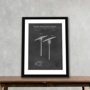 May include: Framed patent print featuring two illustrations of a pick. The print is in black and white, with the text "United States Patent Office" at the top. The pick designs are labeled "Fig. 1" and "Fig. 2". The frame is black.