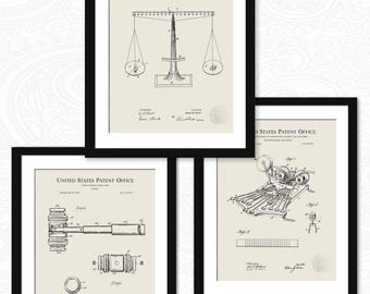 May include: Three framed patent prints featuring vintage designs. The prints are in black frames with off-white backgrounds. The prints include a balance scale, a gavel, and a machine. Each print has the words "United States Patent Office".