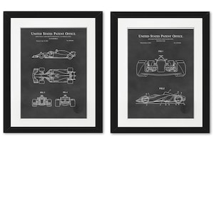 May include: Two black framed prints of a vintage patent drawing for a race car. The drawings are in white on a black background. The text "United States Patent Office" is at the top of each print.