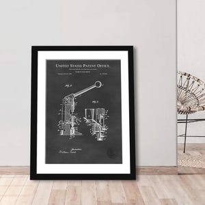 May include: Black framed patent print of a tablet machine. The print, from the United States Patent Office, features detailed technical drawings of the machine's components. The text includes the patent date and inventor's name. The print is displayed on a white background.