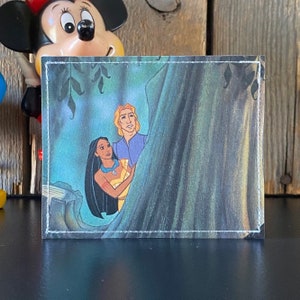 May include: A vintage trading card featuring a cartoon image of Pocahontas and John Smith from the Disney movie Pocahontas. The image shows the two characters standing together in a forest setting.