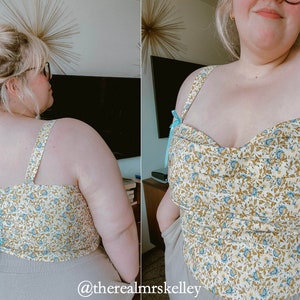 May include: A white and blue floral print top with a sweetheart neckline and adjustable straps. The top has a fitted bodice and a cropped length. The straps are tied at the back with a blue ribbon.