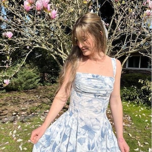 A picture of the Riviera Dress in blue floral. Illustrations fo 3 design options - midi dress, mini dress, and corset top. The sewing pattern comes in sizes 00-36 and includes 6 different design options.