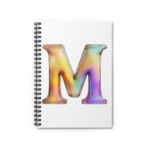May include: Spiral-bound notebook with a white cover featuring a large, colorful letter "M". The letter is rendered in a gradient of yellow, orange, blue, and purple hues, giving it a three-dimensional appearance.