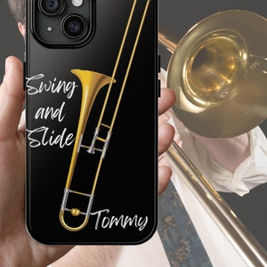 Puede incluir: Funda negra para iPhone con una ilustración de trombón dorado y el texto "Swing and Slide" y "Tommy" en escritura blanca. La funda tiene un acabado brillante y un recorte para la cámara.
