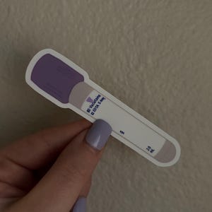 May include: A sticker of a purple-capped blood collection tube with the text "Vacutainer EDTA 5.4mg" printed on the side. The tube is white with gray accents.