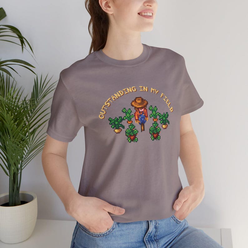 This is a Bella+Canvas 3001 Unisex Jersey Tee with the “Cozy Game Farm Life Shirt Outstanding In My Field Pixel Art for Farming Game Fans” design on the front of the shirt. Image 2