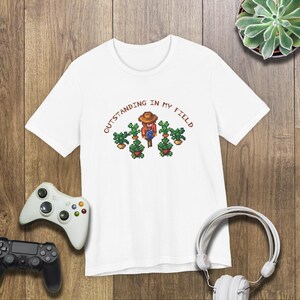 This is a Bella+Canvas 3001 Unisex Jersey Tee with the “Cozy Game Farm Life Shirt Outstanding In My Field Pixel Art for Farming Game Fans” design on the front of the shirt. Image 4