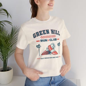 This is a Bella+Canvas 3001 Unisex Jersey Tee with the “Green Hill Run Club Funny Gamer Shirt for 90s Retro Video Game Fans” design on the front of the shirt. Image 2