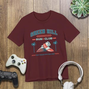 This is a Bella+Canvas 3001 Unisex Jersey Tee with the “Green Hill Run Club Funny Gamer Shirt for 90s Retro Video Game Fans” design on the front of the shirt. Image 4