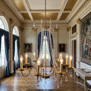 May include: A multi-tiered brass chandelier featuring curved arms, candle-style light sockets, and numerous clear crystal teardrop pendants. The fixture is suspended by a chain from a decorative ceiling medallion in a formal room setting.