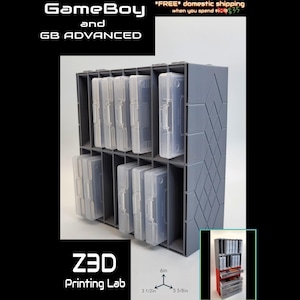 May include: A gray 3D-printed storage unit for GameBoy and GB Advanced game cartridges. The unit has multiple slots to hold the game cartridges. The dimensions are 6 inches high, 3 1/2 inches wide, and 5 5/8 inches deep. The text "GameBoy and GB ADVANCED" is visible.