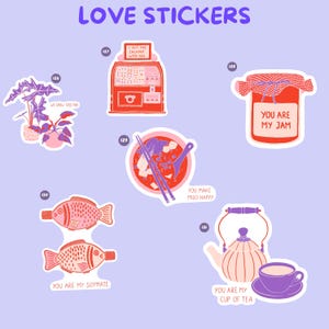 Pu&ograve; includere: Una collezione di adesivi colorati a tema amore su sfondo viola chiaro. Gli adesivi includono una pianta, una slot machine, un barattolo di marmellata, una ciotola di zuppa di miso, due pesci e una teiera con una tazza.
