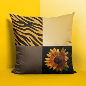 May include: A decorative cushion with a patchwork design featuring a black and orange zebra print, a beige fabric, a brown textured fabric, and a sunflower.