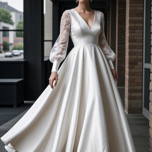 K&ouml;nnte beinhalten: Ein wei&szlig;es Satin-Hochzeitskleid mit V-Ausschnitt und langen &Auml;rmeln. Die &Auml;rmel sind aus durchsichtiger Spitze und haben ein bauschiges Design. Das Kleid hat ein tailliertes Oberteil und einen flie&szlig;enden Rock.