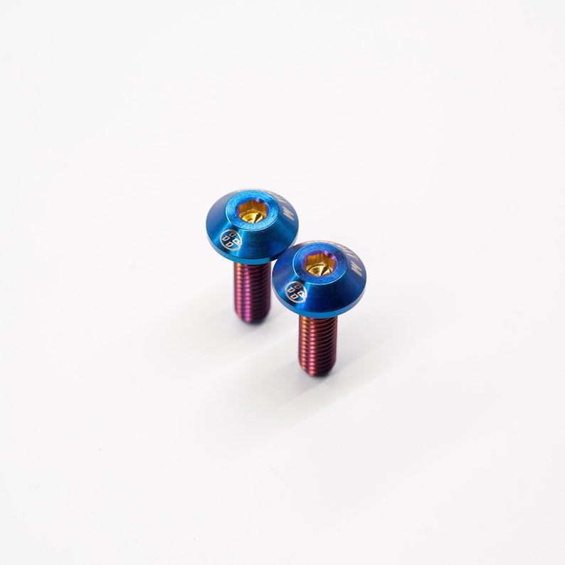 May include: Two blue titanium screws with gold accents and a rainbow finish.